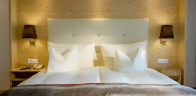 Golfhotel Les Hauts de Gstaad & SPA in Saanenmöser – Komfortables Hotelbett mit weißen Kissen | Wellnesshotel Berner Oberland