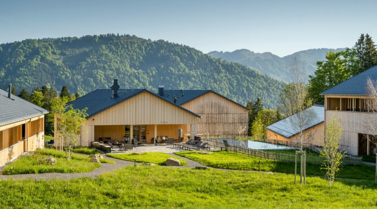 Fuchsegg Eco Lodge in Egg – Hotelanlage mit Außenpool und grünen Hügeln | Wellnesshotel Bregenzerwald