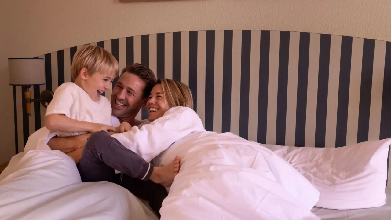 IFA Alpenhof Wildental in Mittelberg – Familie lacht und spielt gemeinsam im gemütlichen Hotelzimmer | Wellnesshotel Vorarlberg