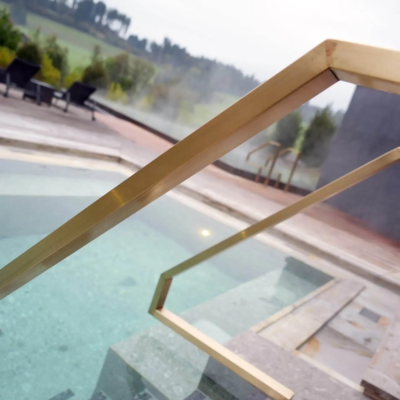 Tannenhof Sport & SPA in Weiler-Simmerberg – Goldener Handlauf am dampfenden Außenpool | Wellnesshotel Allgäu