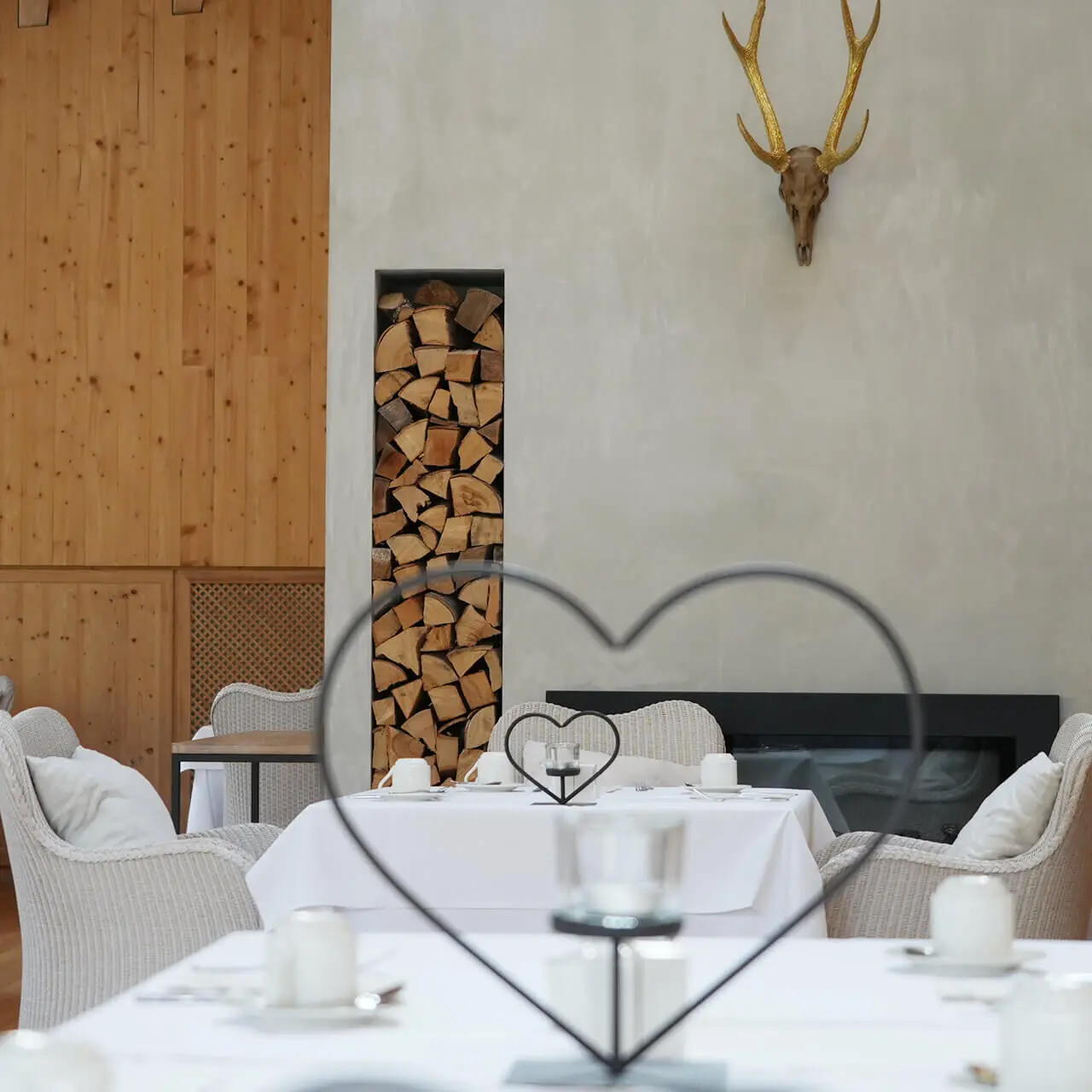 Tannenhof Sport & SPA in Weiler-Simmerberg – Gemütlicher Essbereich mit Kamin und Hirschgeweih | Wellnesshotel Allgäu