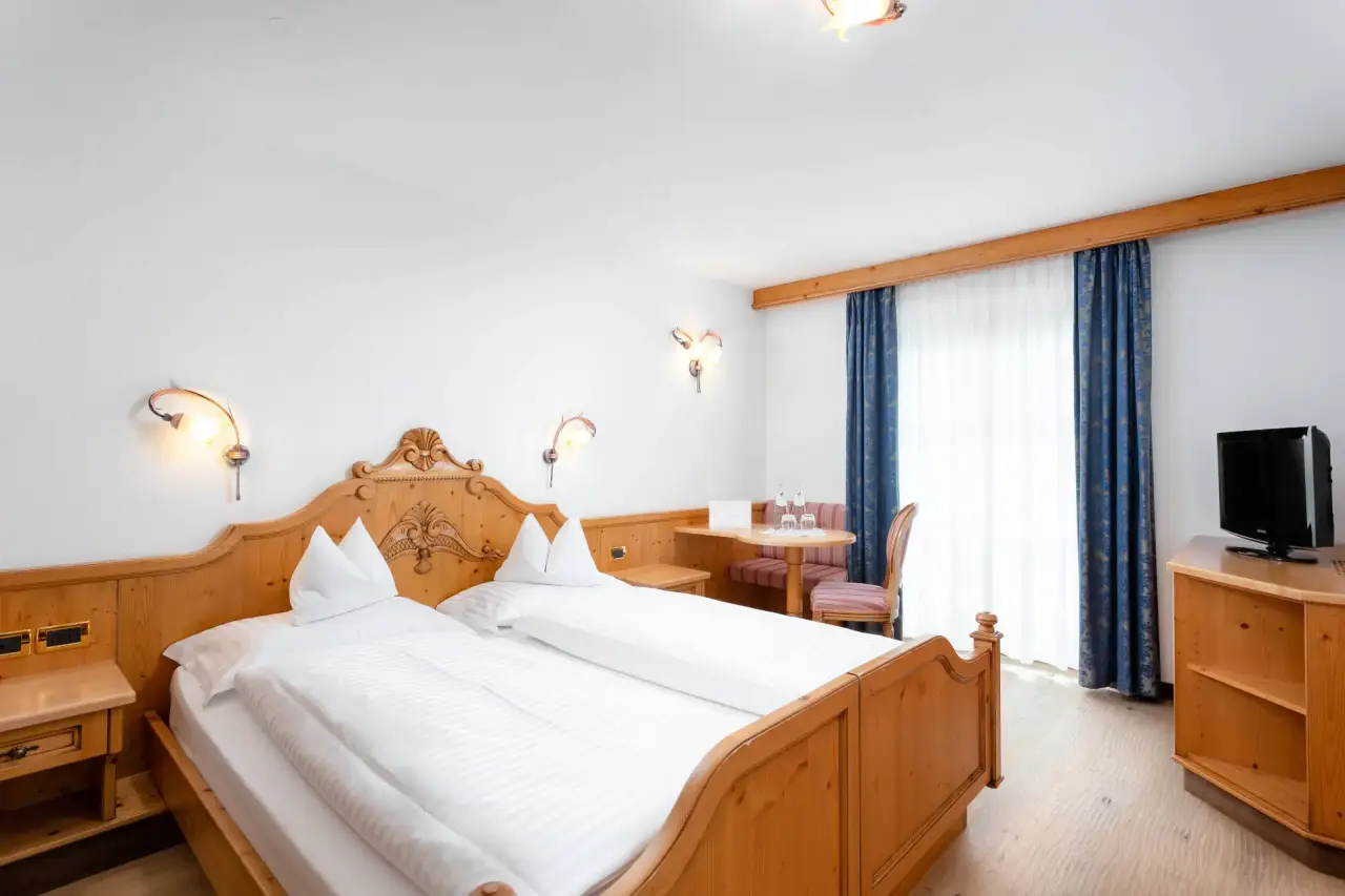 The Cacciatora Wellness & Beauty Hotel in Canazei – Helles Doppelzimmer mit Sitzbereich | Wellnesshotel Dolomiten