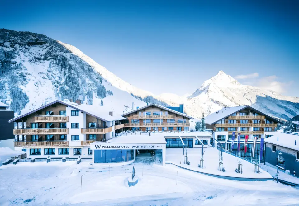 Wellnesshotel Warther Hof in Warth – Winterliche Außenansicht mit verschneiten Bergen | Wellnesshotel Arlberg