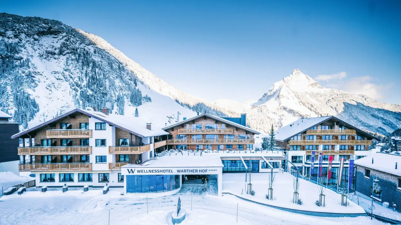 Wellnesshotel Warther Hof in Warth – Winterliche Außenansicht mit verschneiten Bergen | Wellnesshotel Arlberg