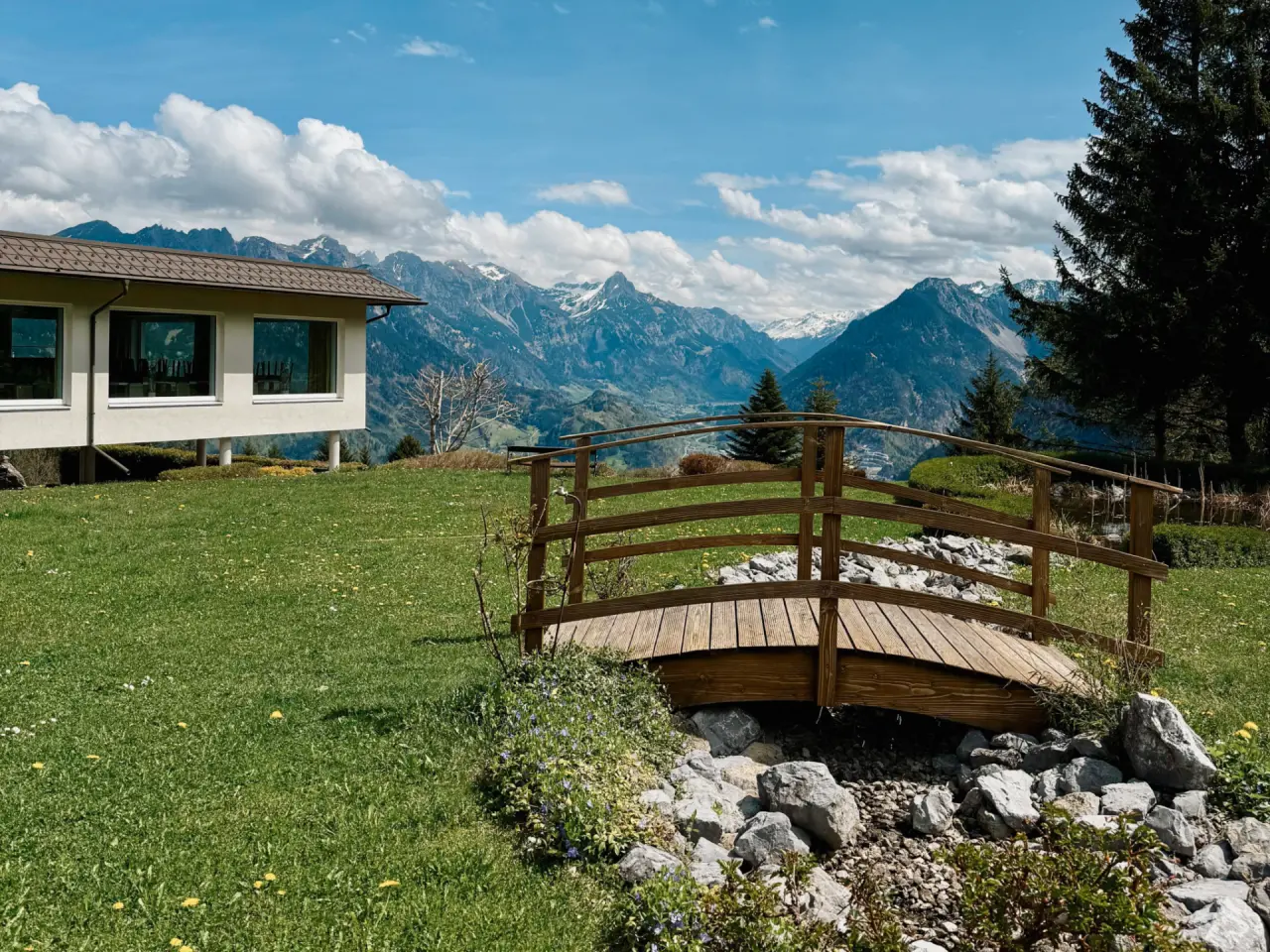 Alpinresort Schillerkopf in Bürserberg – Hotelgebäude mit Brücke und Alpenpanorama | Wellnesshotel Vorarlberg