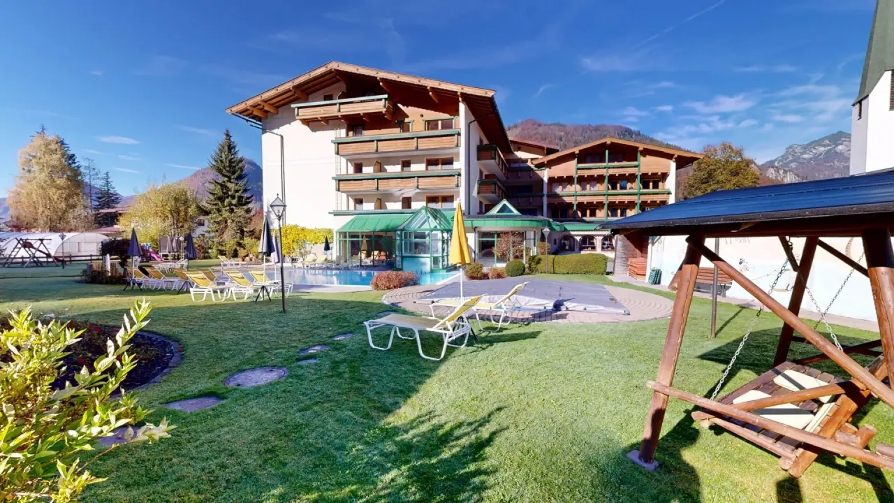 Vitalhotel Berghof in Erpfendorf – Hotelgarten im Herbst mit Liegewiese und Bergblick | Wellnesshotel Tirol