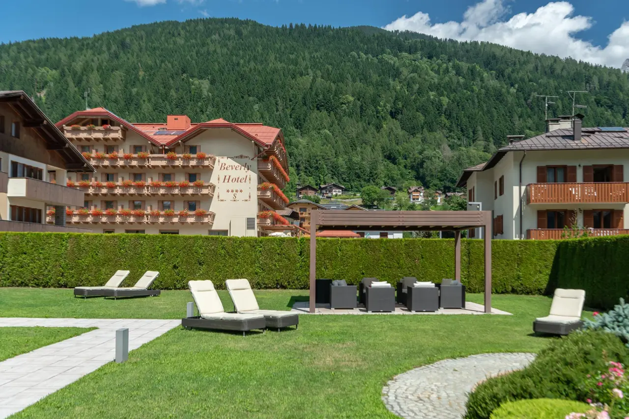 Beverly Alps Hotel & Spa in Pinzolo – Hotelaußenansicht mit Garten und Liegewiesen | Wellnesshotel Dolomiten