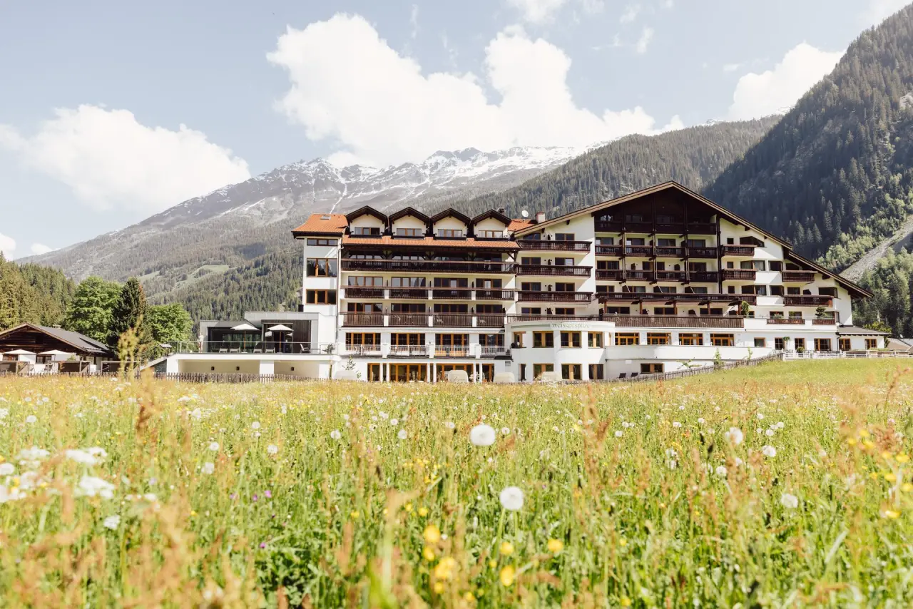 Hotel Weisseespitze in Kaunertal – Hotelgebäude umgeben von Bergwiesen und Alpenpanorama | Wellnesshotel Tirol