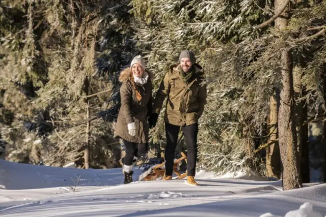 Hotel Sonnenhof in Lam – Glückliches Paar beim Winterspaziergang im verschneiten Wald | Wellnesshotel Bayerischer Wald