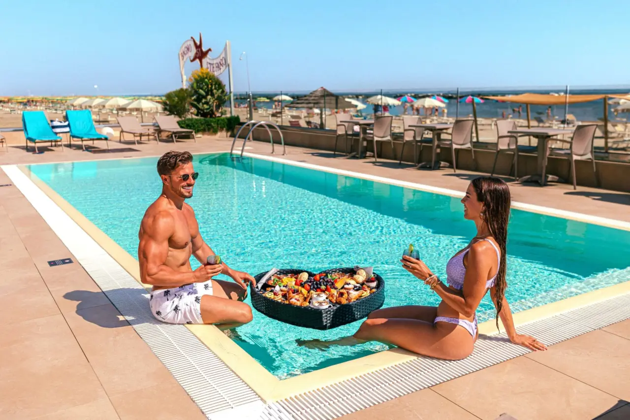 You & Me Beach Hotel in Rimini – Paar genießt Obstplatte am Pool mit Blick auf den Strand | Wellnesshotel Emilia-Romagna