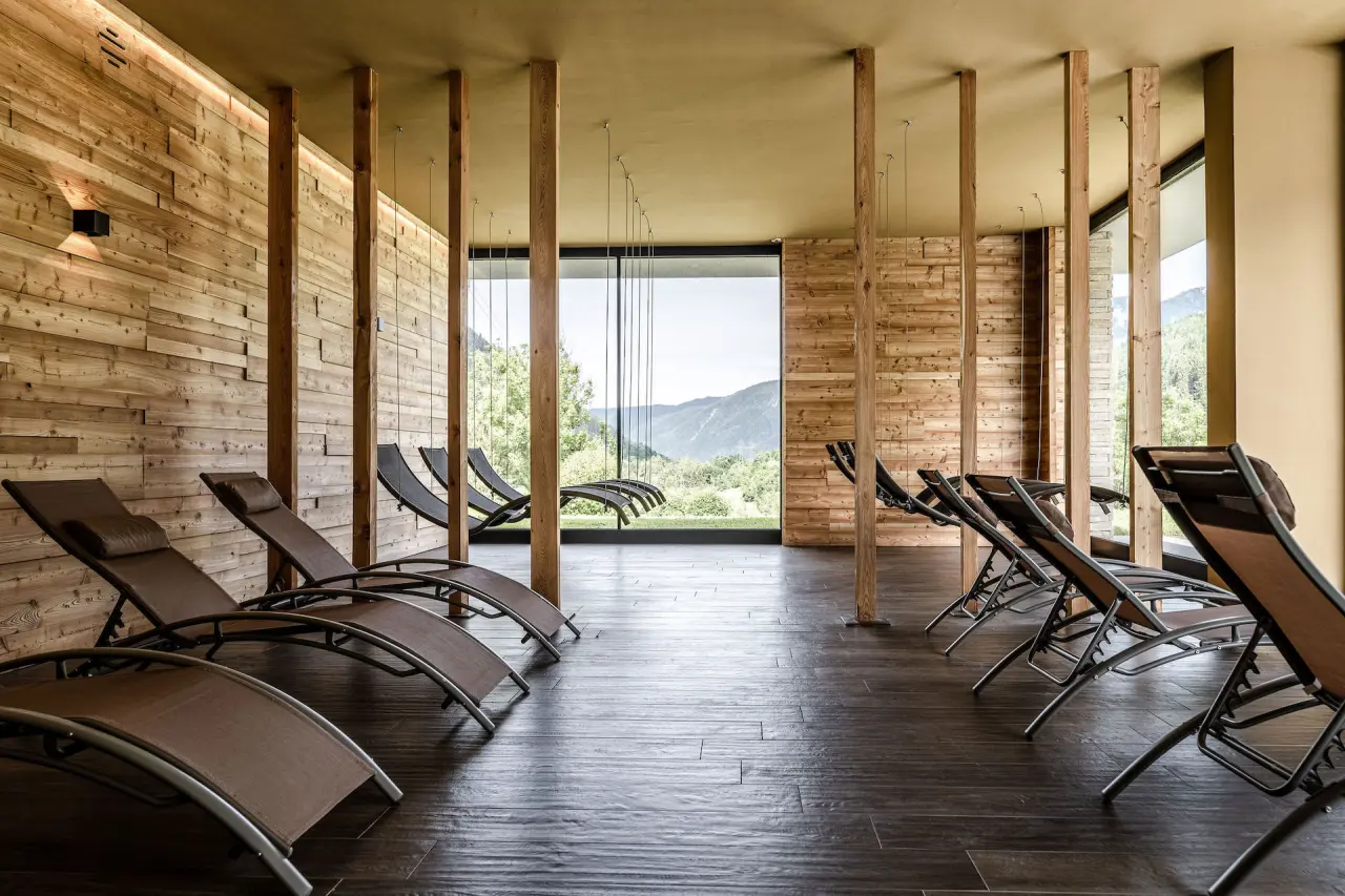 Gaia Wellness Residence Hotel in Mezzana – Entspannter Ruheraum mit Holzwand und Bergblick | Wellnesshotel Trentino