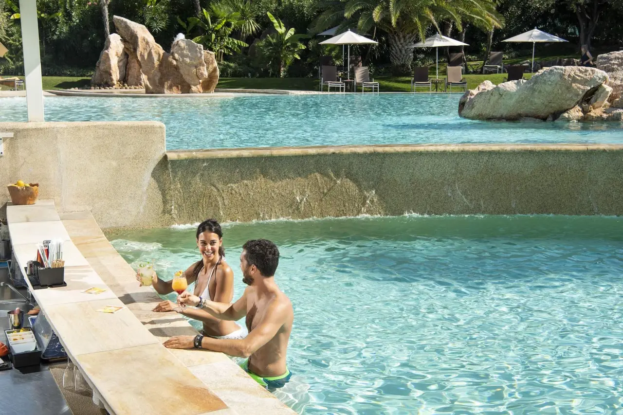 Color Hotel Style & Design in Bardolino – Paar genießt Cocktails an der Swim-up-Bar im Pool | Wellnesshotel Gardasee
