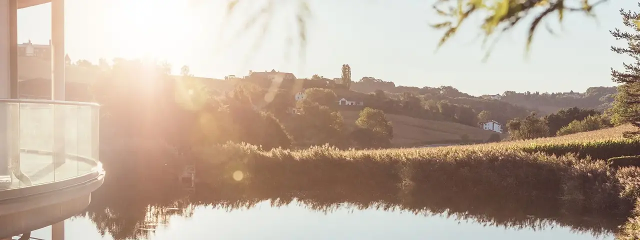 Thermenhotel Vier Jahreszeiten Loipersdorf in Bad Loipersdorf – Malerische Landschaft mit See und Hotelbalkon | Wellnesshotel Steiermark