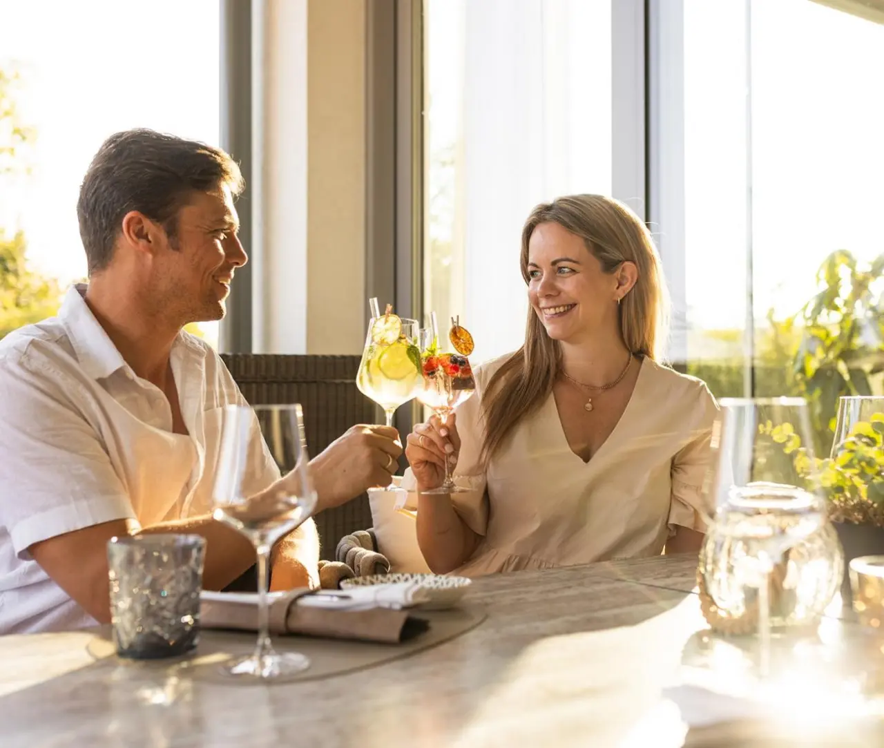 VILA VITA Pannonia in Pamhagen – Glückliches Paar beim Anstoßen im Außenbereich | Wellnesshotel Burgenland