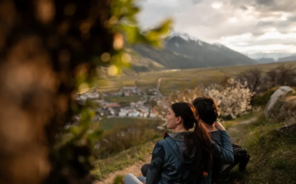 Hotel das Paradies in Schlanders – Paar genießt den Ausblick auf das Tal und die Berge | Wellnesshotel Vinschgau