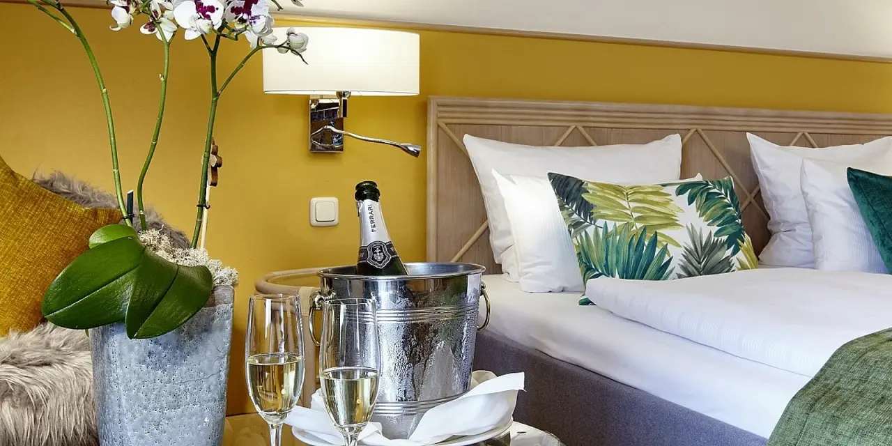 Parkhotel Weiskirchen in Weiskirchen – Hotelzimmer mit Champagner und Orchidee am Bett | Wellnesshotel Saarland