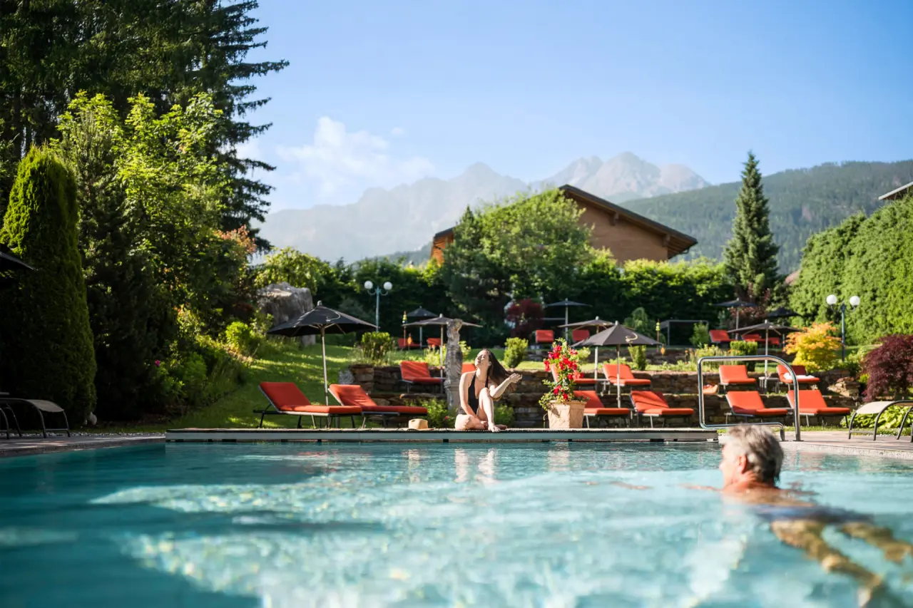 Mirabell Dolomites Hotel in Bruneck – Außenpoolbereich im Sommer mit Gästen und Liegestühlen | Wellnesshotel Dolomiten