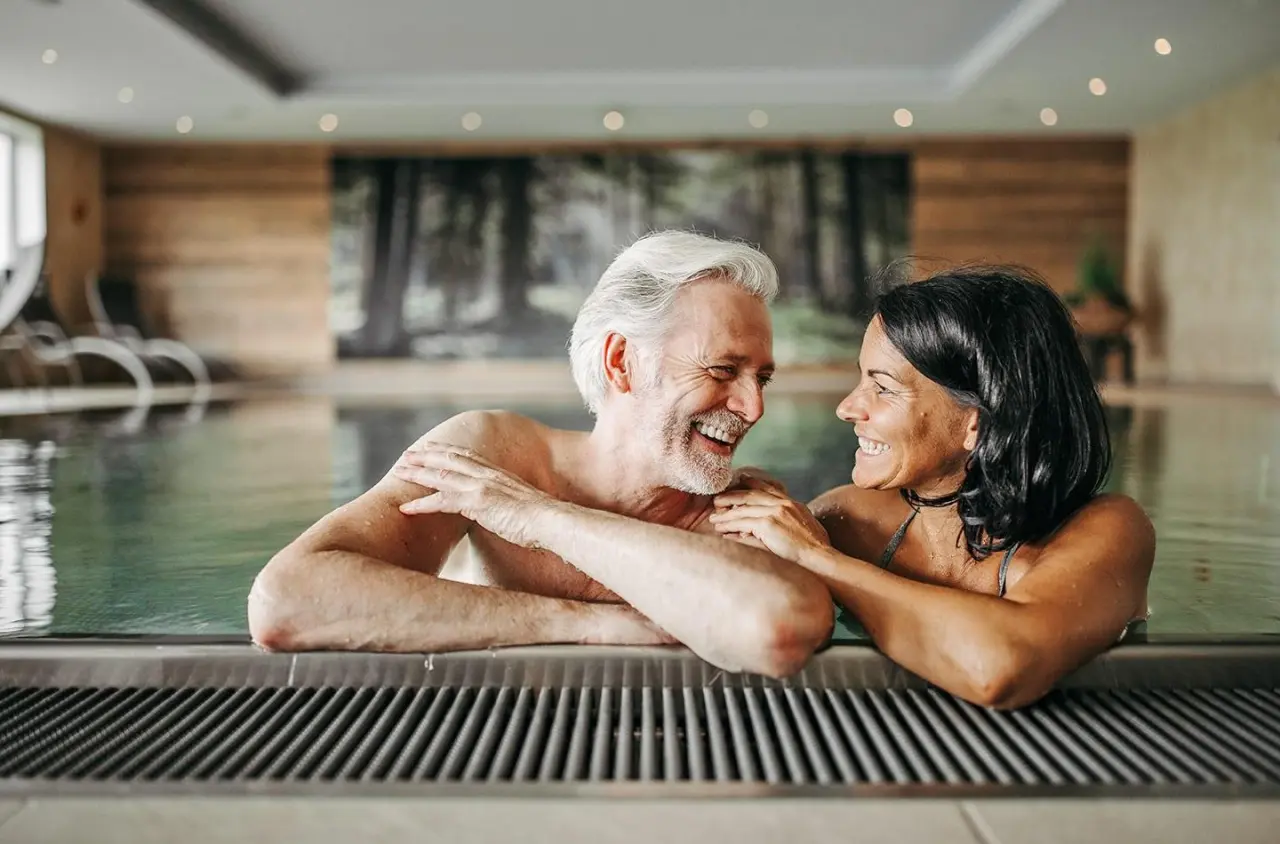 Hotel Waldfrieden in Rohrmoos Schladming – Glückliches Paar entspannt im Innenpool | Wellnesshotel Steiermark