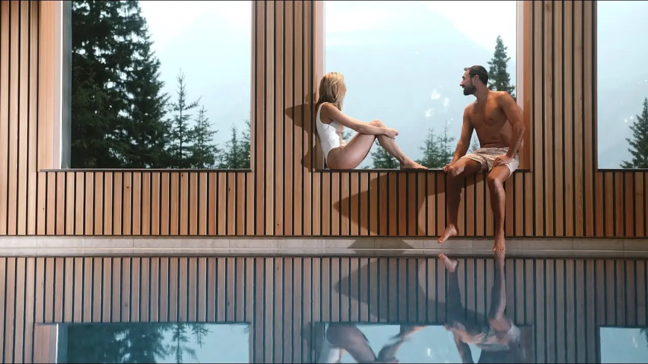 Waldhotel Arosa in Arosa – Hallenbad mit Holzverkleidung und Bergblick | Wellnesshotel Graubünden