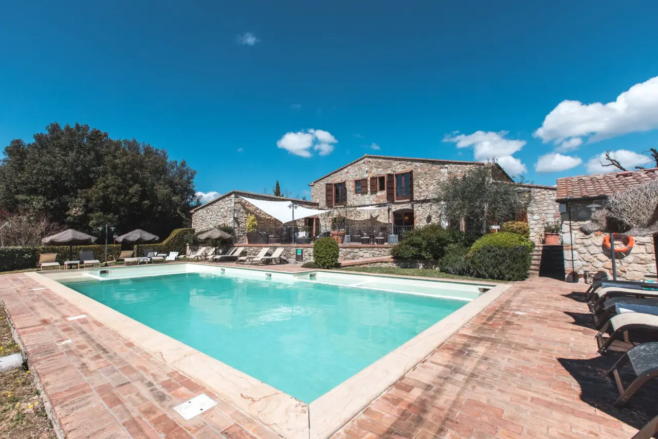 La Melosa Resort & Spa in Roccastrada – Außenpoolbereich mit Sonnenliegen und Hotelgebäude | Wellnesshotel Toskana
