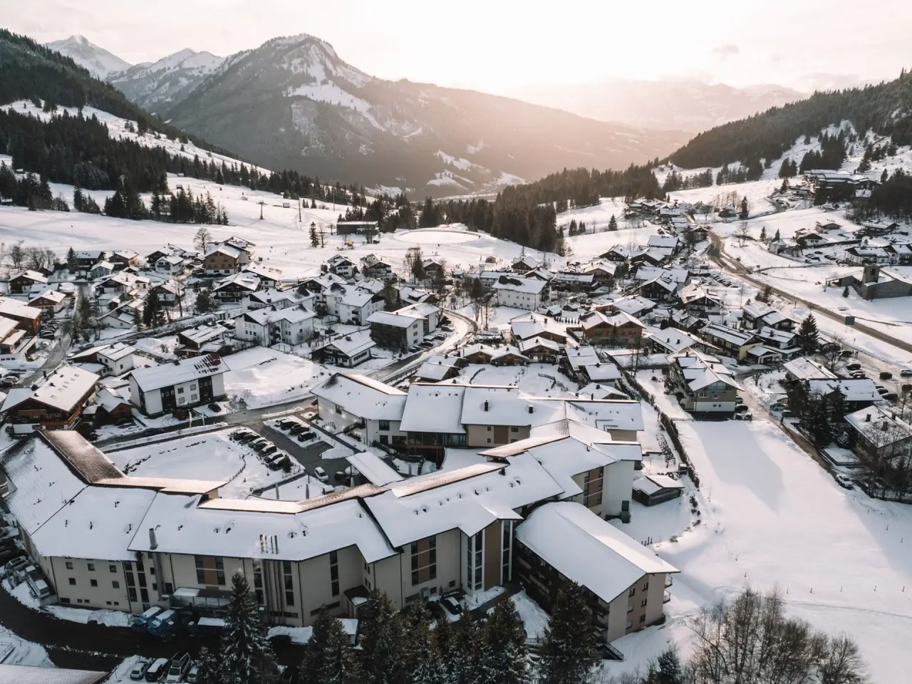 Parkhotel Jordanbad in Biberach – Winterliche Luftaufnahme des Hotels mit verschneiten Bergen | Wellnesshotel Oberschwaben