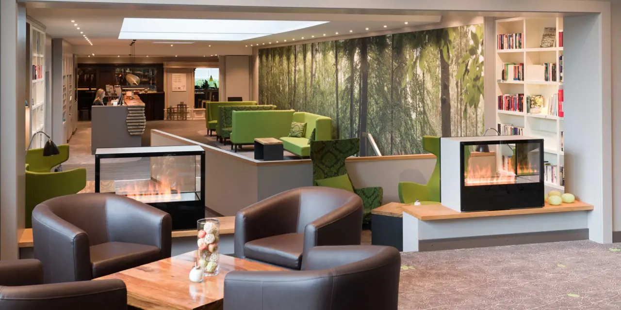 Hotel Munte am Stadtwald in Bremen – Gemütliche Lobby mit Kamin und Waldmotiv | Wellnesshotel Bremen
