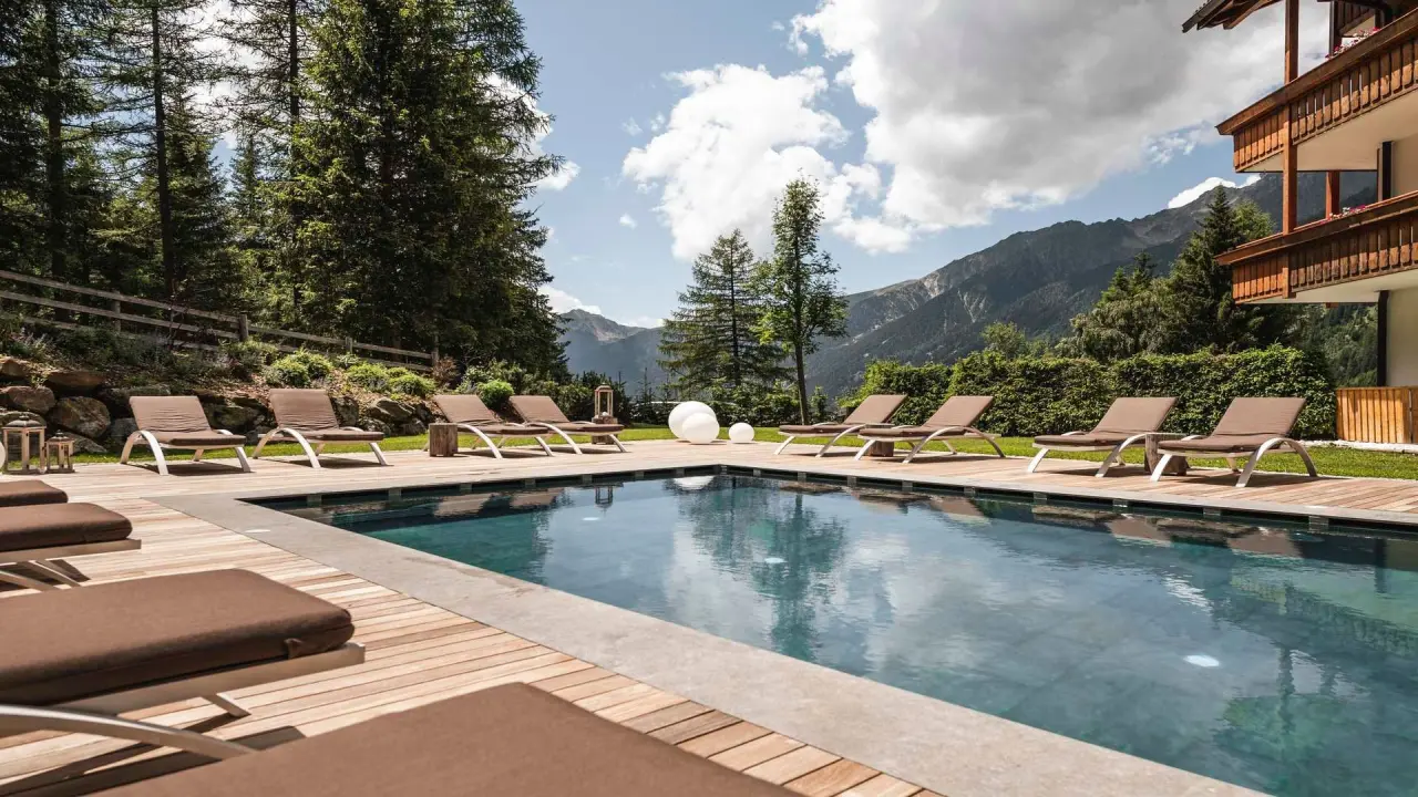 Falkensteiner Hotel Antholz in St. Martin in Gsies – Außenpool mit Liegen und Bergblick | Wellnesshotel Antholz