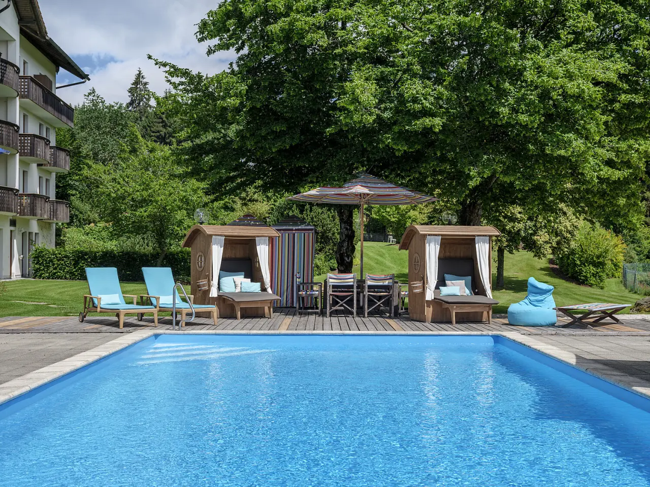 Berghotel Maibrunn in St. Englmar – Außenpool mit Liegebereich und Hotelgebäude | Wellnesshotel Bayerischer Wald