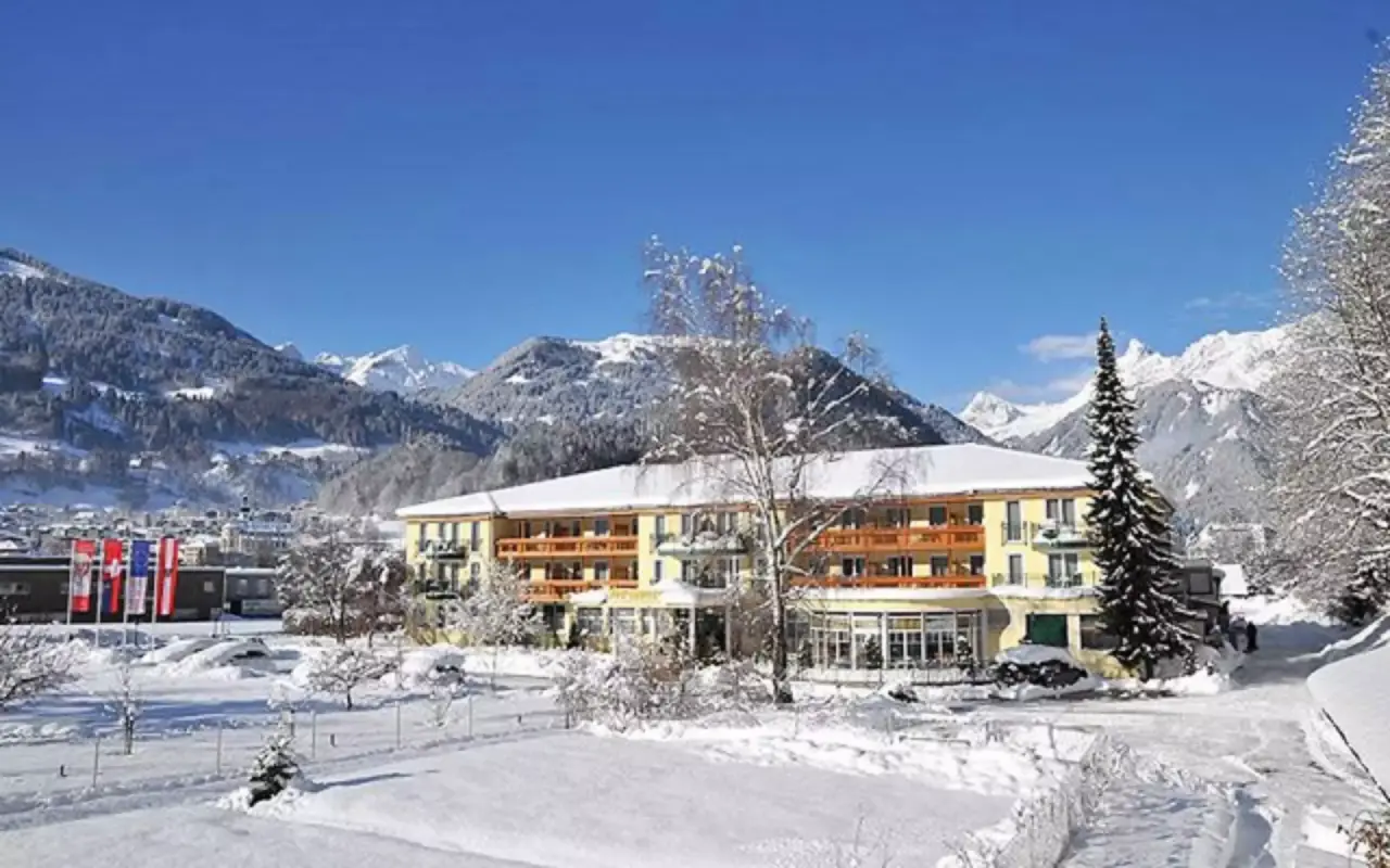Vitalquelle Montafon in Schruns – Hotelgebäude im Winter mit verschneiten Bergen | Wellnesshotel Montafon