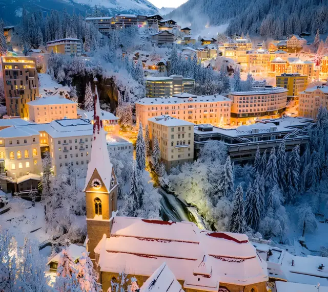 EUROPÄISCHER HOF Aktivhotel & Spa in Bad Gastein – Winterliche Ortsansicht bei Nacht mit beleuchteter Kirche | Wellnesshotel Salzburger Land