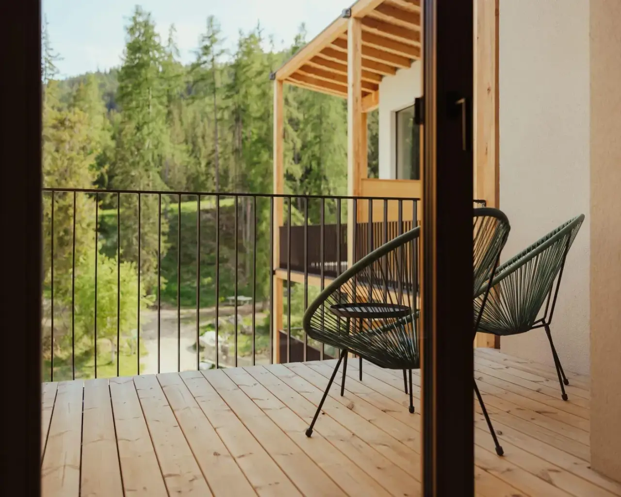 Hotel Restaurant Lëch da Sompunt in La Villa – Balkon mit Sitzgelegenheiten und Blick auf den Wald | Wellnesshotel Dolomiten
