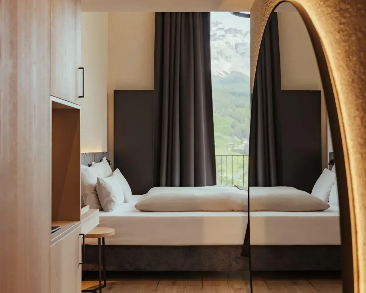 Hotel Restaurant Lëch da Sompunt in La Villa – Gemütliches Doppelzimmer mit Bergblick, im Spiegel reflektiert | Wellnesshotel Dolomiten