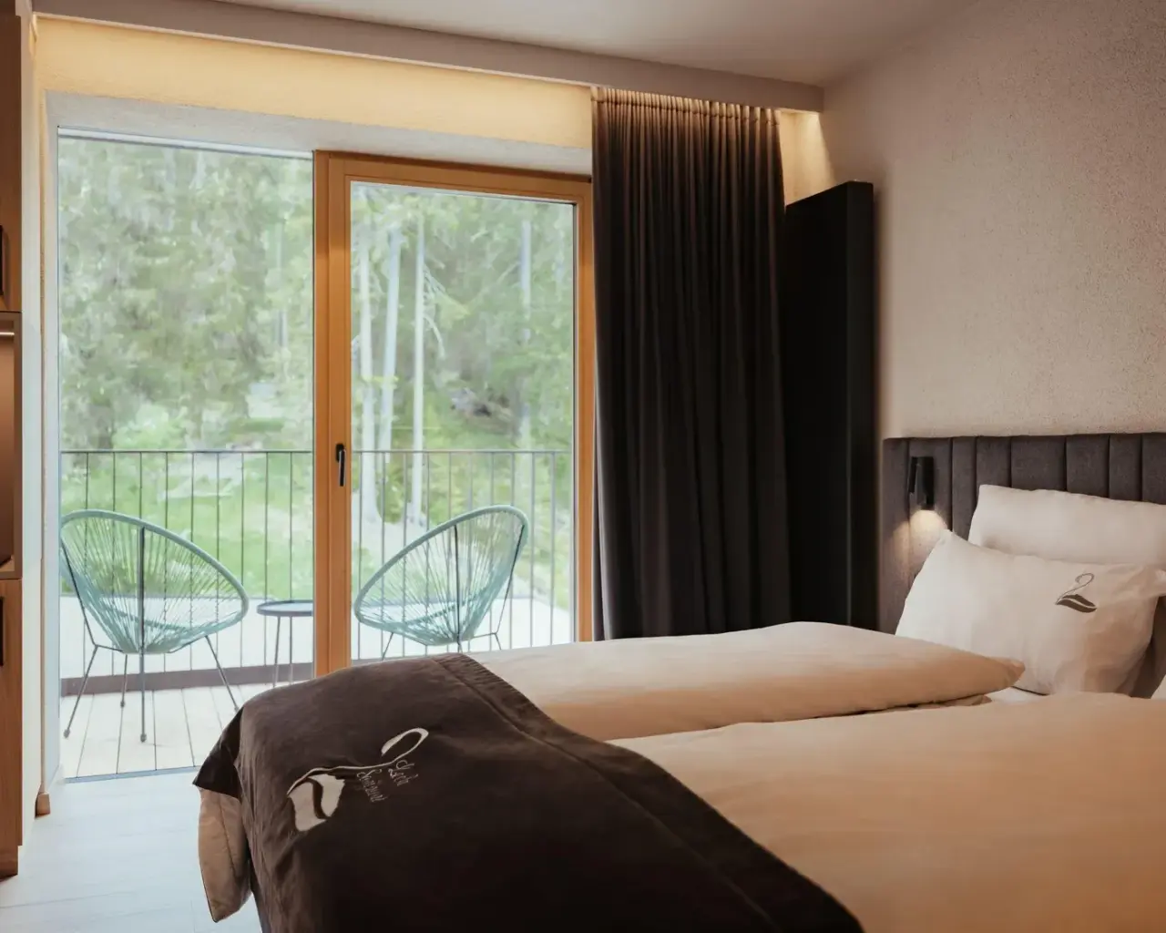 Hotel Restaurant Lëch da Sompunt in La Villa – Modernes Hotelzimmer mit Balkon und Waldblick | Wellnesshotel Dolomiten