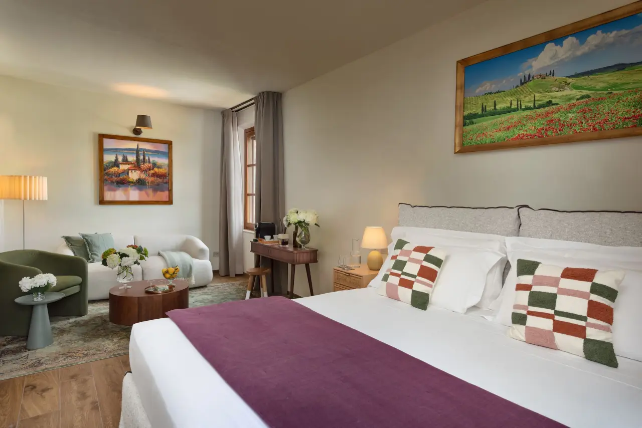 Poggio Paradiso Resort & Spa in Torrita di Siena – Komfortable Suite mit Bett und gemütlicher Sitzecke | Wellnesshotel Toskana