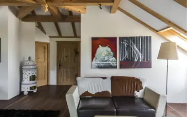 Romantik Hotel Turm in Kastelruth – Gemütlicher Wohnbereich mit Kaminofen und Holzbalken | Wellnesshotel Südtirol