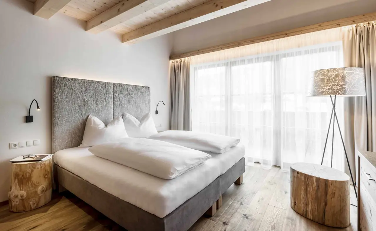 Hotel Stoeres in La Villa – Modernes Doppelzimmer mit Holzbalken und Balkon | Wellnesshotel Dolomiten