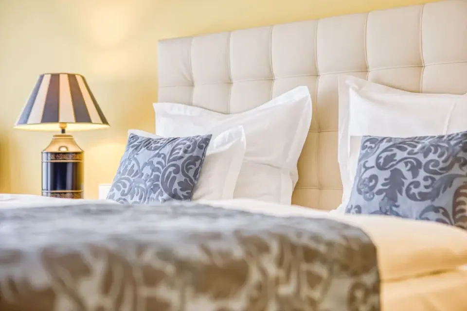 Wald & Schlosshotel Friedrichsruhe in Zweiflingen – Gemütliches Bett mit Kissen und Nachttischlampe | Wellnesshotel Hohenlohe