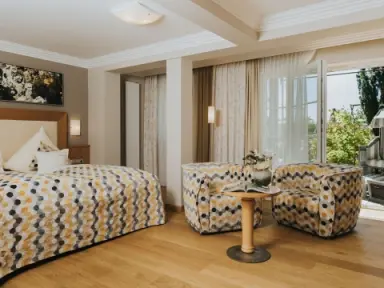 Ortner's Resort in Bad Füssing – Helles Hotelzimmer mit Sitzbereich und Balkon | Wellnesshotel Rottal