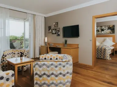 Ortner's Resort in Bad Füssing – Geräumiger Wohnbereich mit Fernseher und Schlafzimmerzugang | Wellnesshotel Rottal