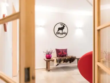 Hotel BERGEBLICK in Bad Tölz – Gemütliche Sitzecke mit Hirsch-Dekoration | Wellnesshotel Oberbayern