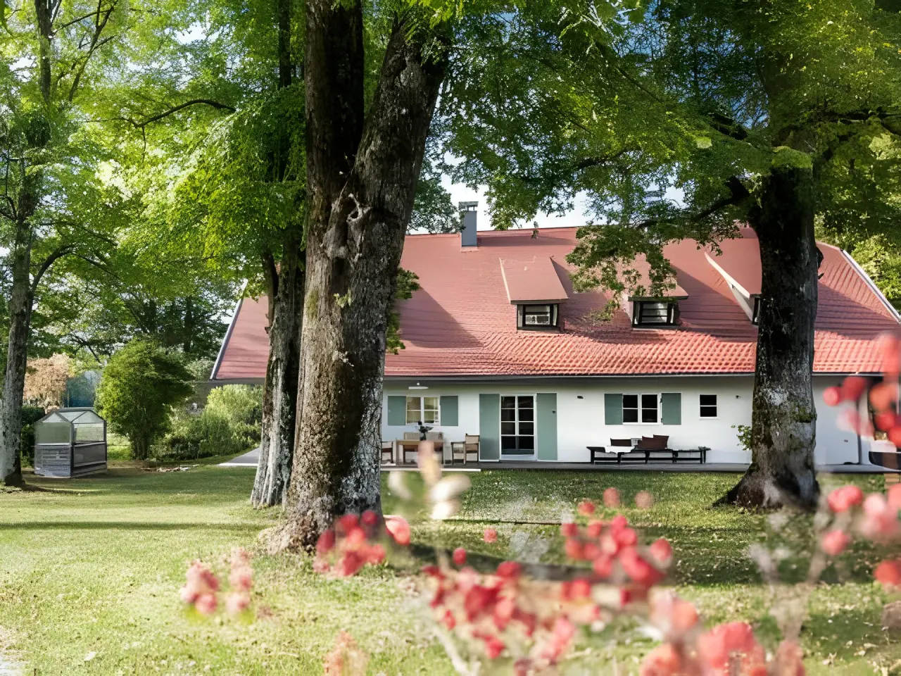 Hotel BERGEBLICK in Bad Tölz – Hotelgebäude umgeben von Bäumen und Grünflächen | Wellnesshotel Oberbayern