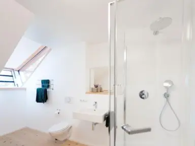 Hotel BERGEBLICK in Bad Tölz – Modernes Badezimmer mit Dusche und Dachfenster | Wellnesshotel Oberbayern