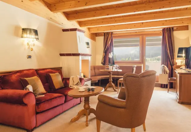 ALPENPALACE Luxury Hideaway & Spa Retreat in Luttach – Gemütliches Wohnzimmer mit Kamin und Bergblick | Wellnesshotel Ahrntal