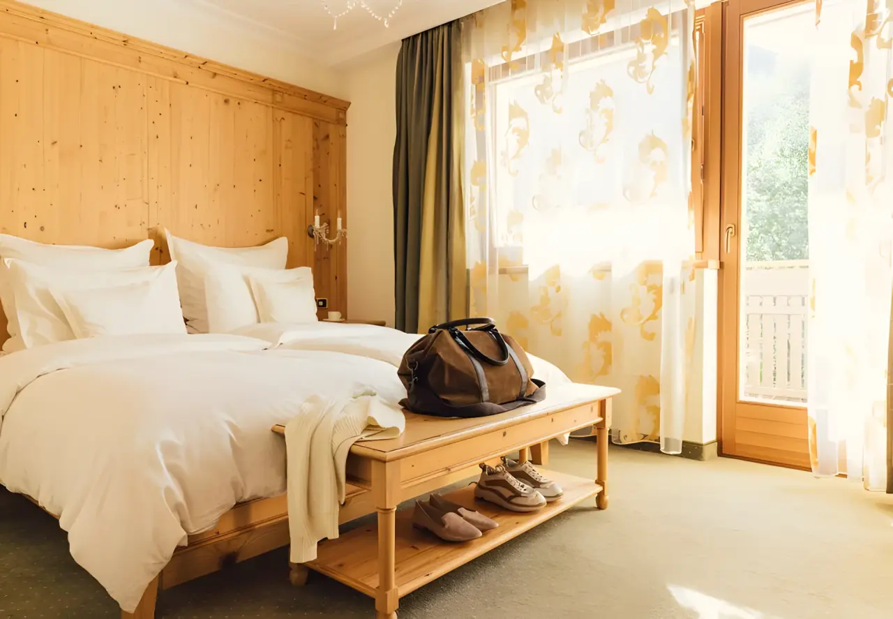 ALPENPALACE Luxury Hideaway & Spa Retreat in Luttach – Helles Schlafzimmer mit Holzbetten und Balkonzugang | Wellnesshotel Ahrntal
