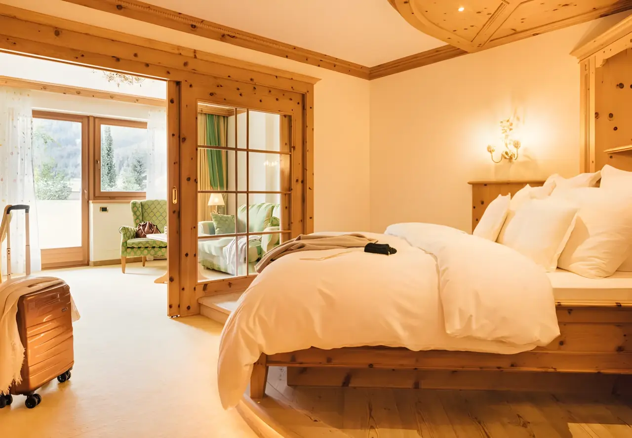 ALPENPALACE Luxury Hideaway & Spa Retreat in Luttach – Komfortables Schlafzimmer mit Holzelementen und Balkon | Wellnesshotel Ahrntal