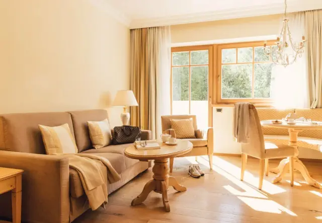 ALPENPALACE Luxury Hideaway & Spa Retreat in Luttach – Helle Suite mit Wohnbereich und Esstisch | Wellnesshotel Südtirol