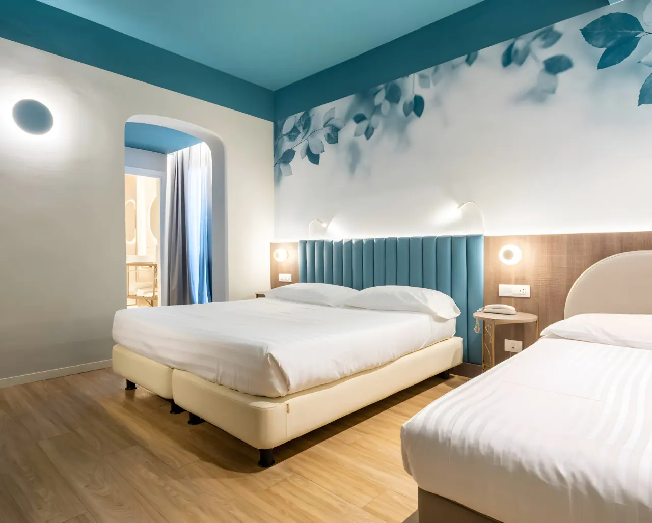 Hotel Regina Elena 57 in Rimini – Modernes Dreibettzimmer mit blauer Akzentwand | Wellnesshotel Emilia-Romagna