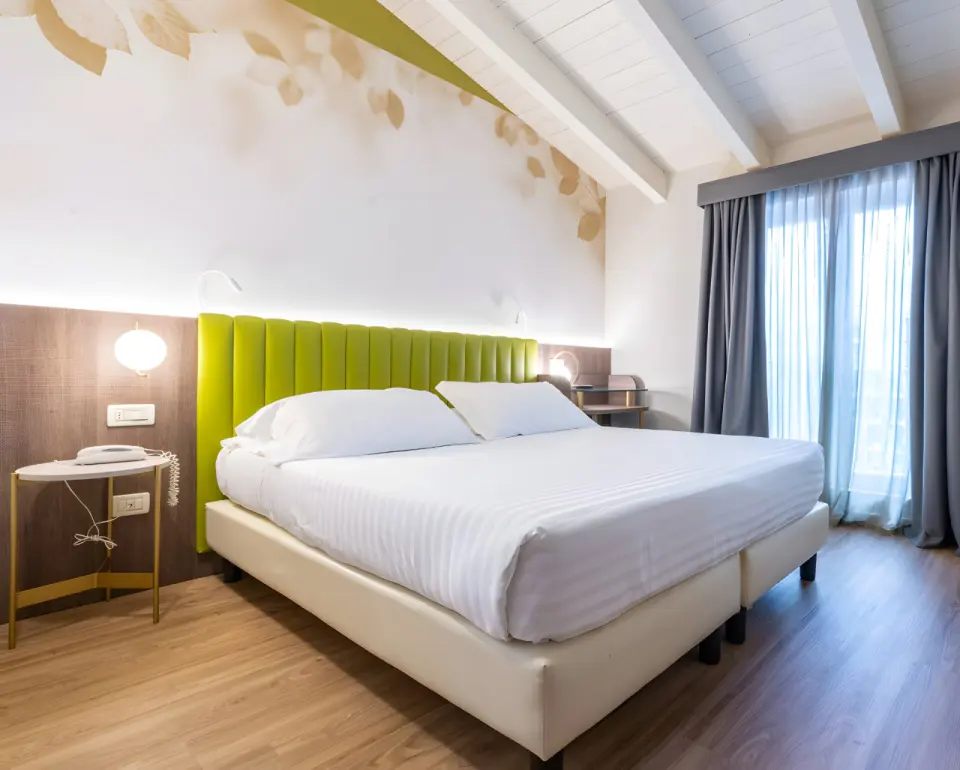 Hotel Regina Elena 57 in Rimini – Doppelzimmer mit Holzbalkendecke und grüner Kopflehne | Wellnesshotel Emilia-Romagna