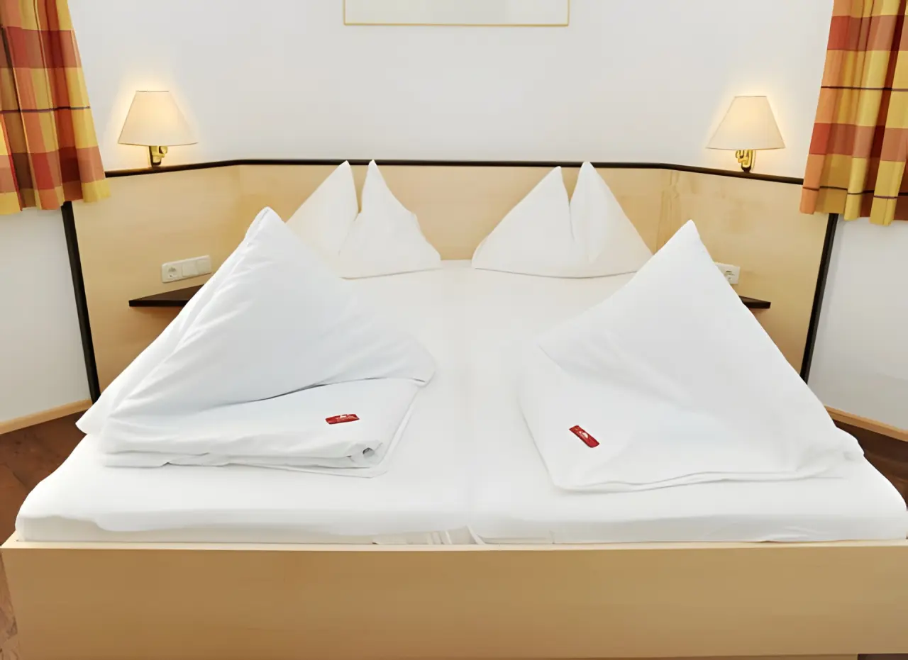 Hotel Alpina in St. Johann im Pongau – Gemütliches Doppelbett im Hotelzimmer | Wellnesshotel Salzburger Land