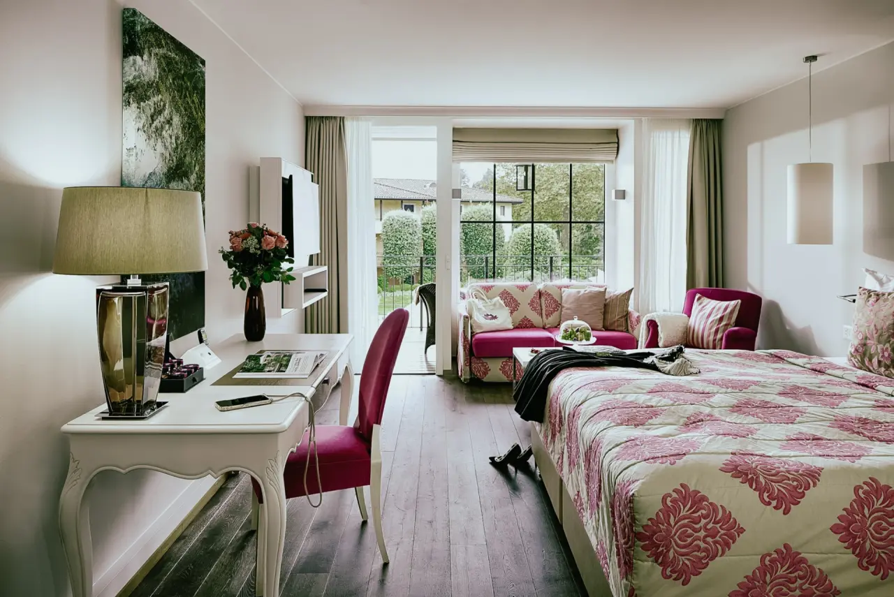 Giardino Ascona in Ascona – Helles Hotelzimmer mit Balkon und gemütlicher Sitzecke | Wellnesshotel Tessin